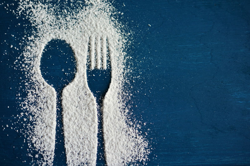 Auf einem Tisch liegen Teller mit klassischen Mezze. Ein Teller zeigt cremigen Hummus mit Kichererbsen und frischen Kräutern, die in der Mitte angerichtet sind. Die anderen Teller enthalten Falafel-Kugeln, perfekt golden gebraten. Plates of classic mezze are laid out on a table. One plate features creamy hummus with chickpeas and fresh herbs arranged in the centre. The other plates contain falafel balls, fried to golden perfection.